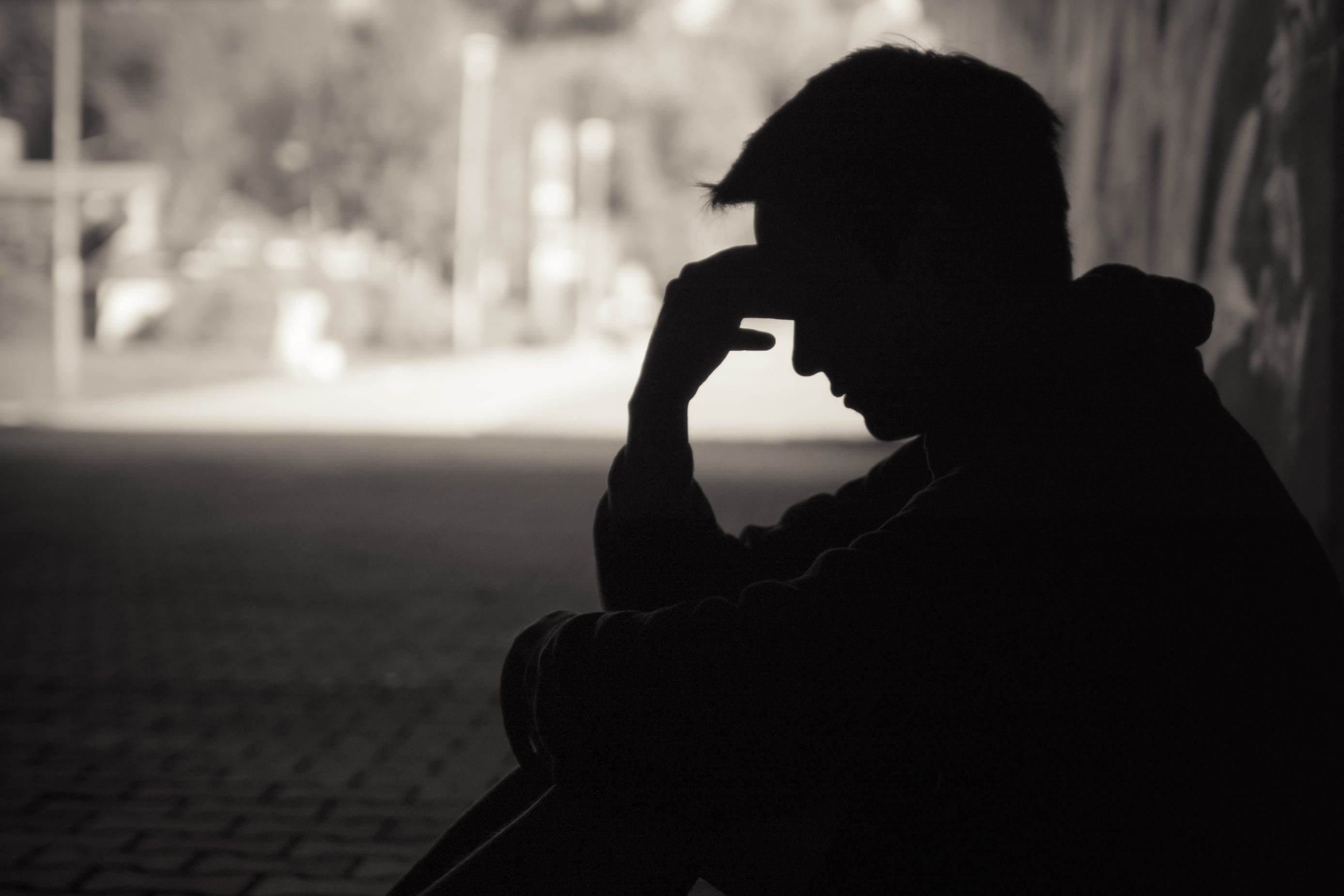Silhouette of a person sitting alone
