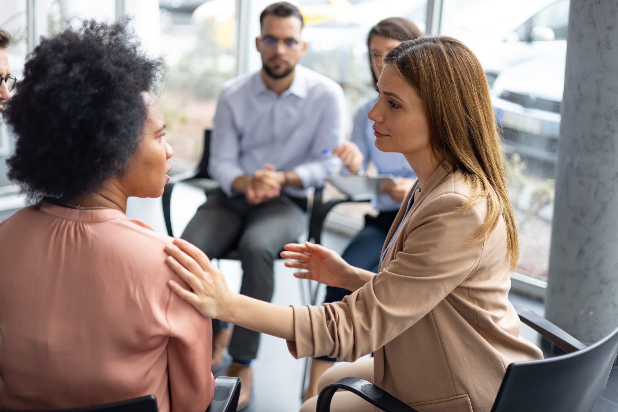 Woman comforting another in meeting