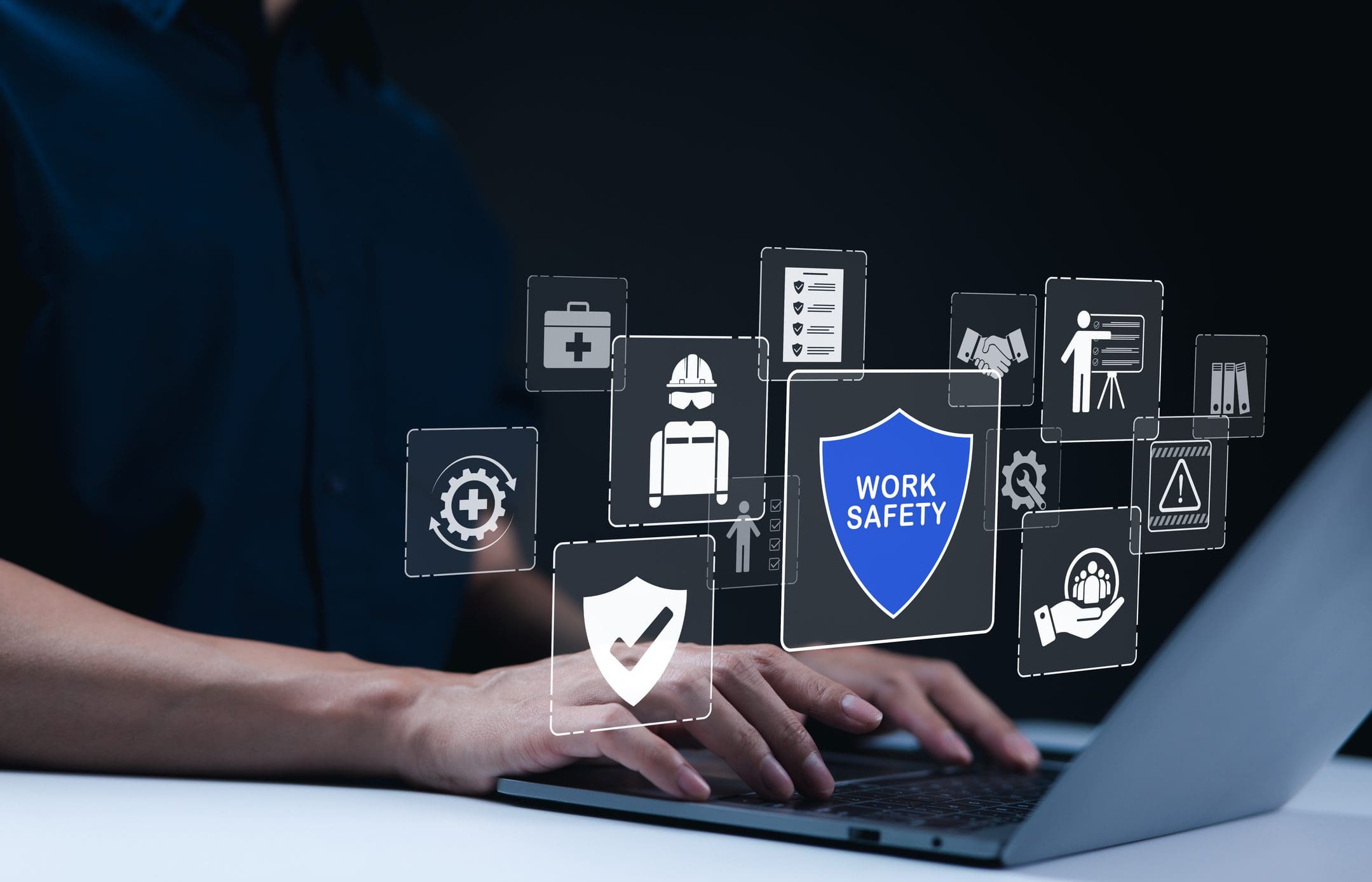 Person typing, work safety icons displayed above.