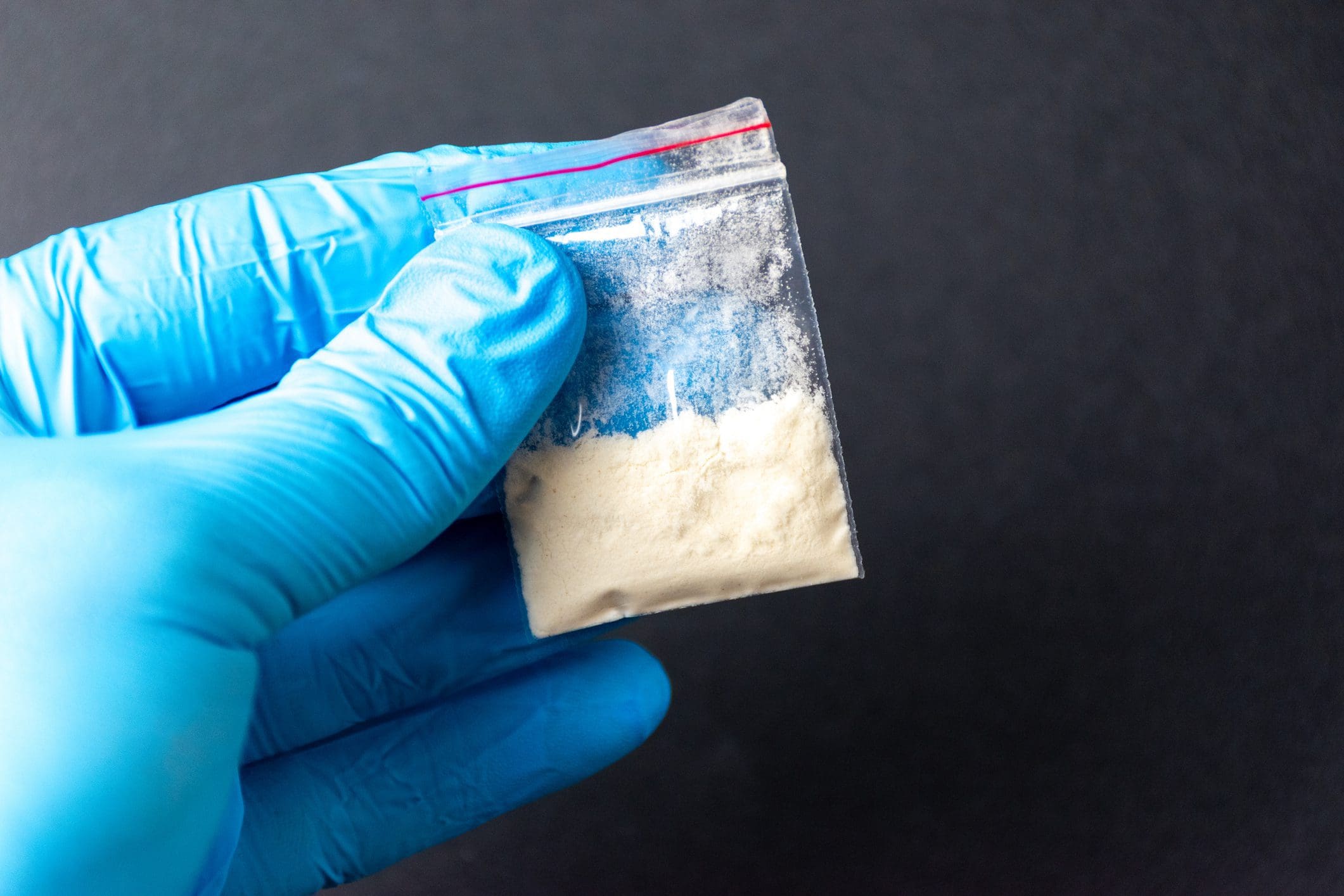 Hand with blue glove and powder bag.