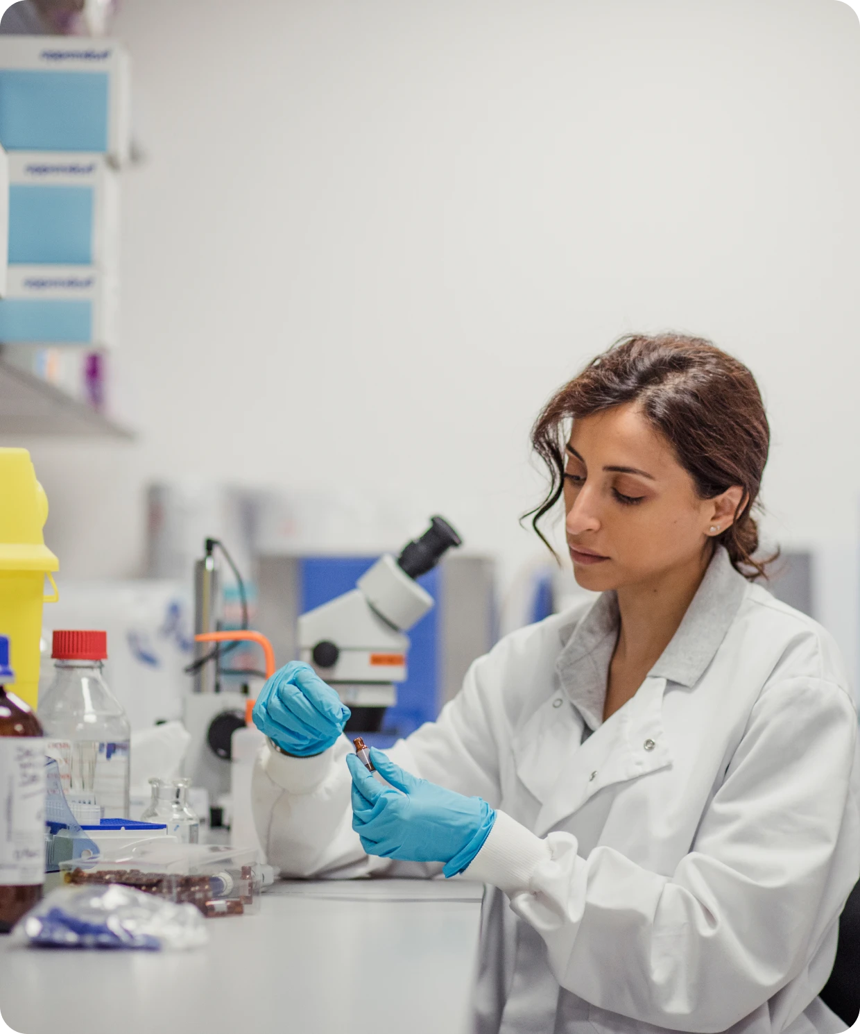 Woman in lab coat using equipment