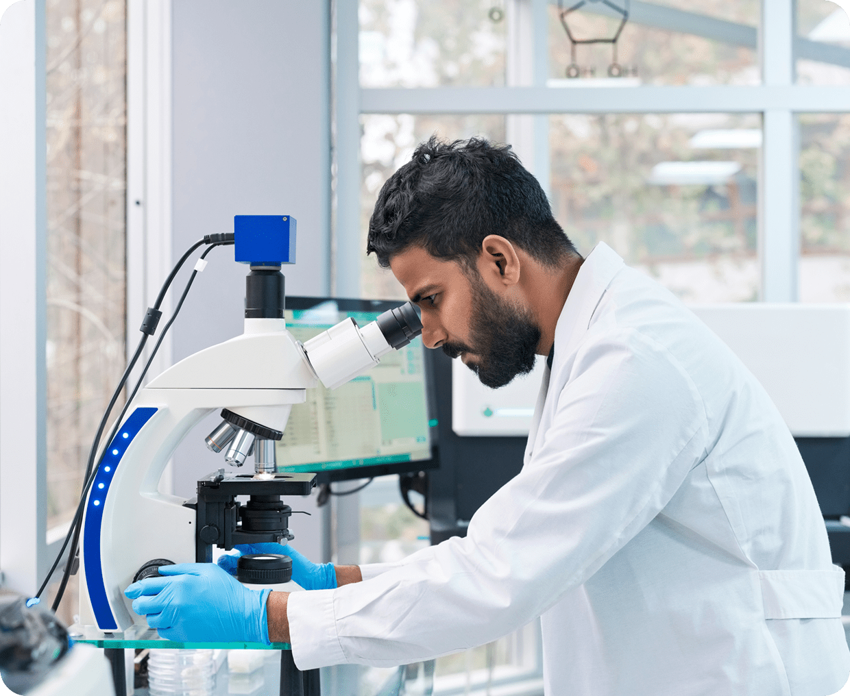 Scientist examining sample under microscope