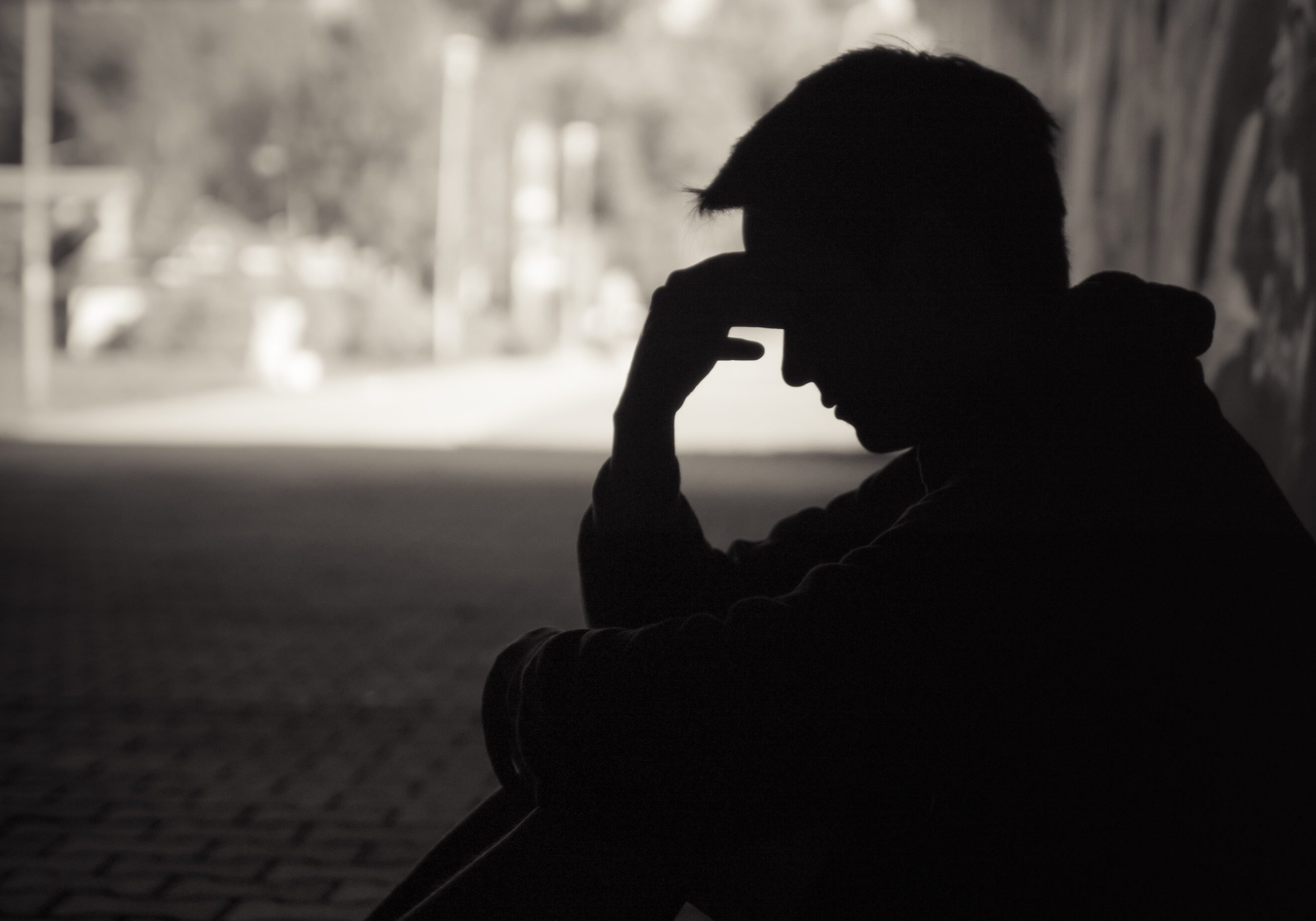 Silhouette of a person sitting alone