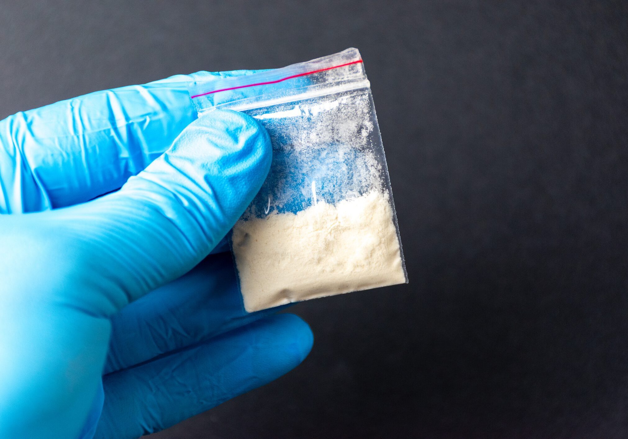 Hand with blue glove and powder bag.